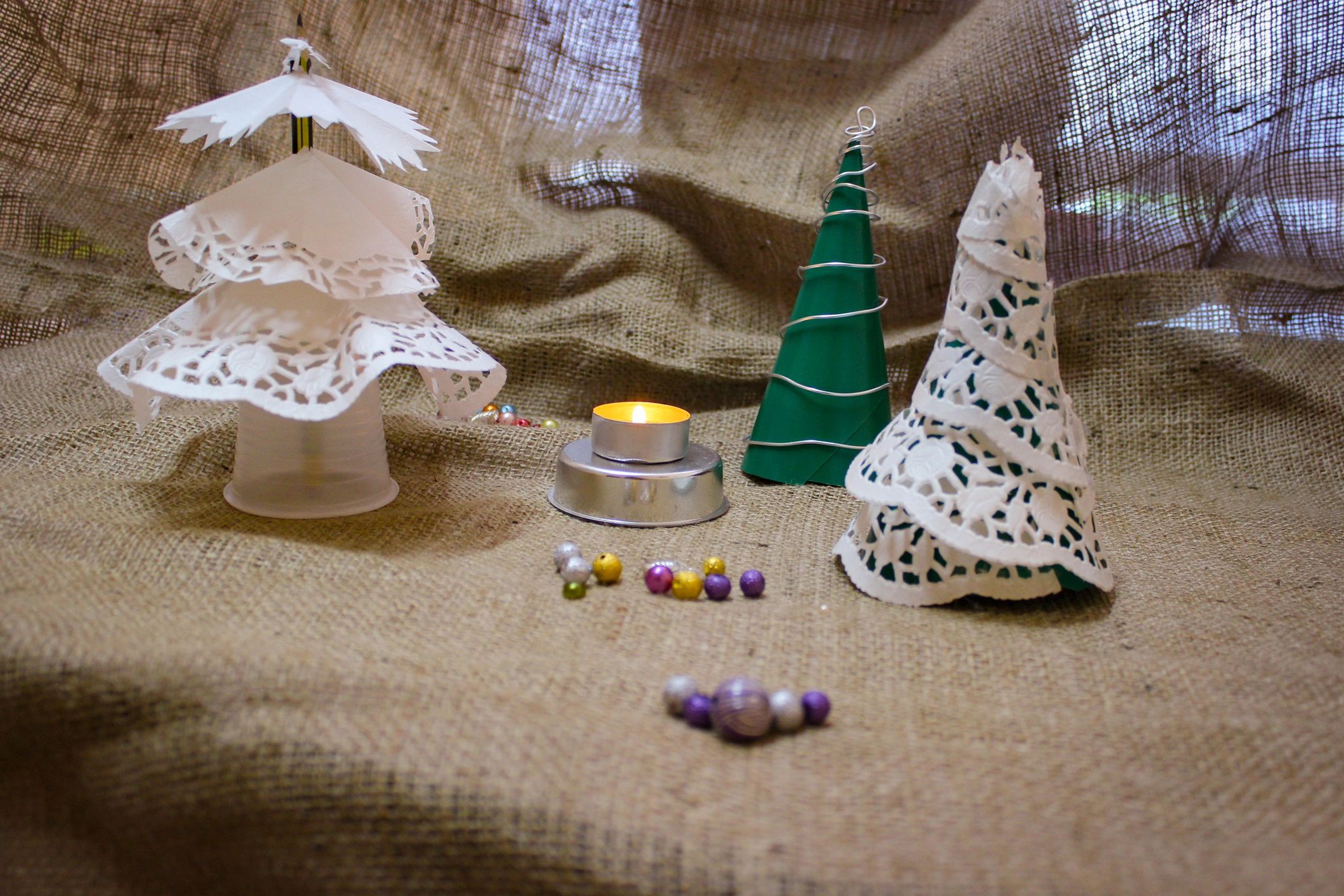 Decorative handmade paper trees and candle styled as a crafted gift display